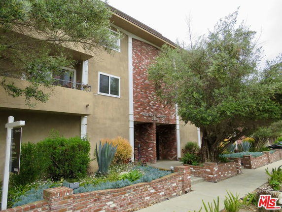 Front view of a multi-story building with brick and stucco exterior.