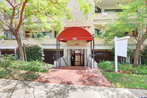 Front view of a multi-story building with a red awning entrance.
