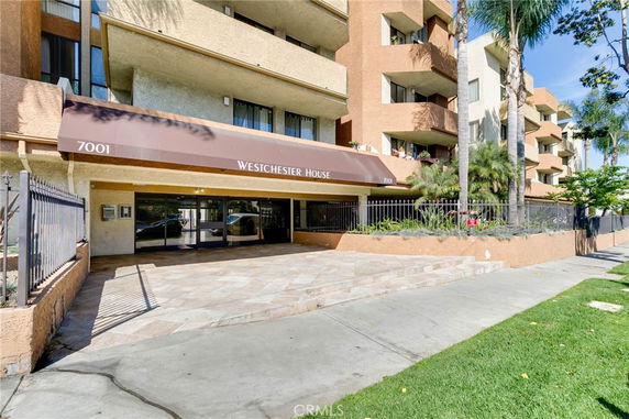 Front view of a multi-story residential building with a covered entrance.