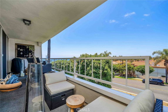 Panoramic view from a balcony overlooking surrounding residential area and trees.