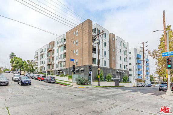 Front view of a multi-story apartment building at a street corner.