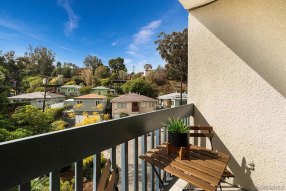 View from a balcony overlooking nearby houses and greenery.