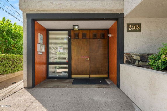 Entrance of a building with double doors and a side window panel.