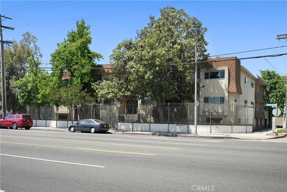 Front view of a two-story residential building with fencing.