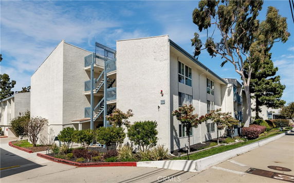 Front view of a multi-story residential building with an exterior staircase.