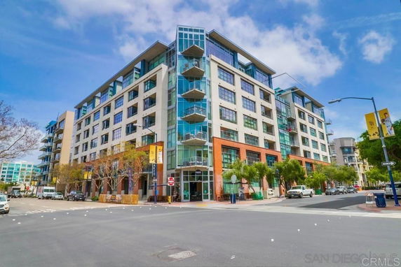 Front view of a modern multi-story apartment building with large windows and balconies.