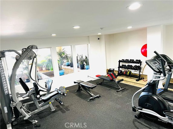 Indoor gym area with exercise equipment and free weights.