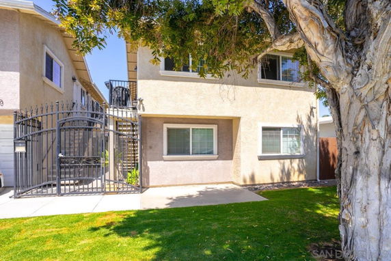 Front view of a two-story house with a gated entry.
