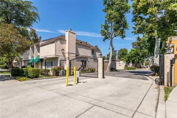 Front view of a two-story residential building with a gated entrance.