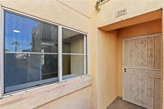 Front view of a building entrance with a metal security door and a window.