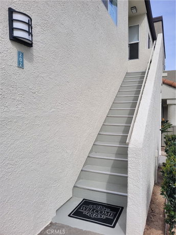 Exterior stairs leading to the entrance of a two-story building.