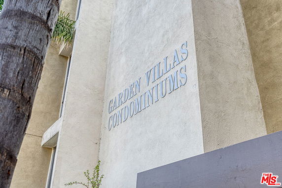 Front view of a condominium building with signage.