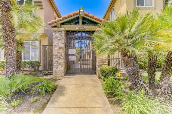Entrance view of a house with stone columns and gate.