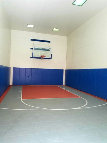 Indoor basketball court with a hoop and padded walls.