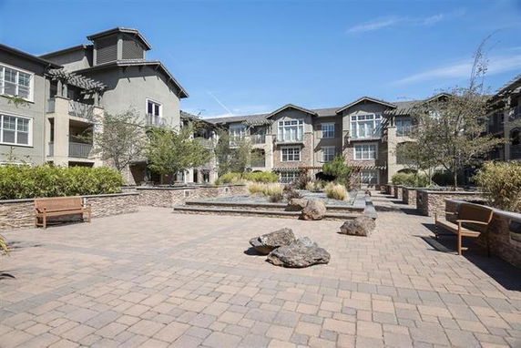 Front view of a multi-story residential building with a courtyard area.
