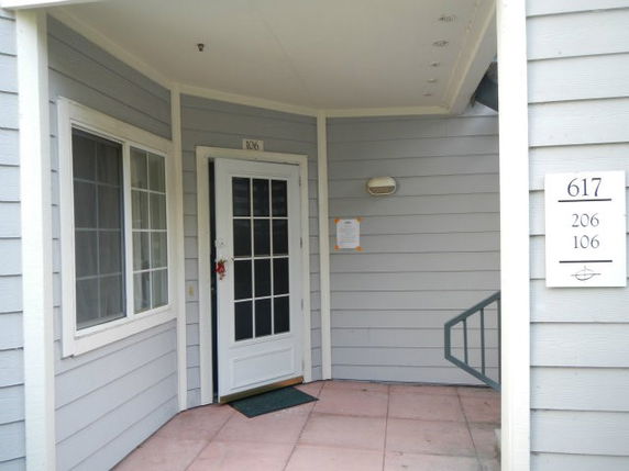 Front view of a house entry with a white door and adjacent windows.