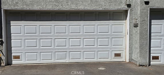 Front view of a garage door attached to a building with textured walls.