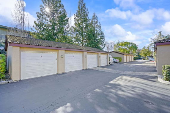 Outdoor parking area with a row of garage units.