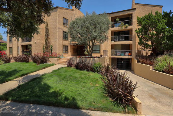 Front view of a multi-story building with balconies and garage entrance.