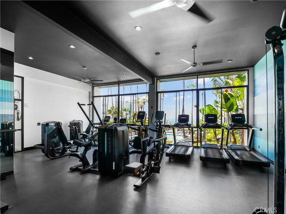 Indoor gym area with exercise machines and large windows.
