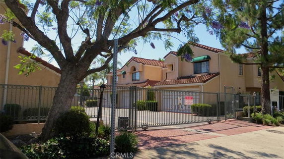Front view of a gated residential complex with two-story houses.
