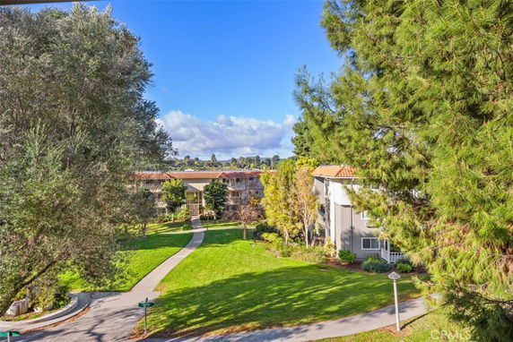 View of residential buildings surrounded by trees and green landscape.