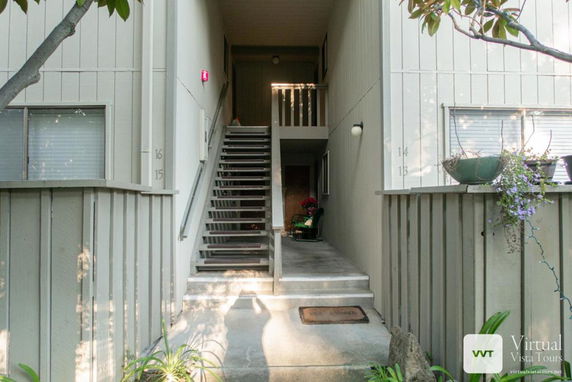 Front view of a multi-story building with external stairway.