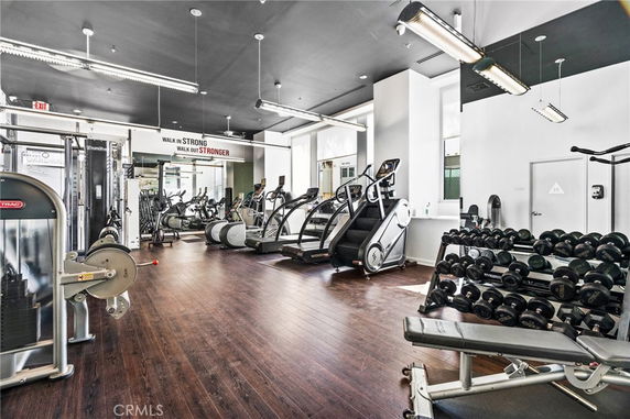 Interior view of a gym with exercise equipment and weights.
