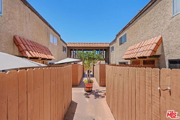 Front view of a multi-story building with tile roof awnings and wooden fences.