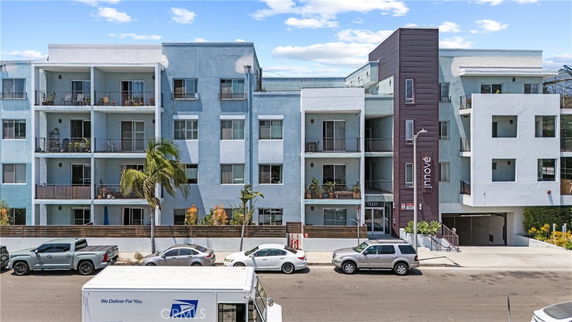 Front view of a multi-story apartment building with balconies.