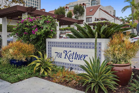 Front view of a residential building with a decorative entrance and name signage.