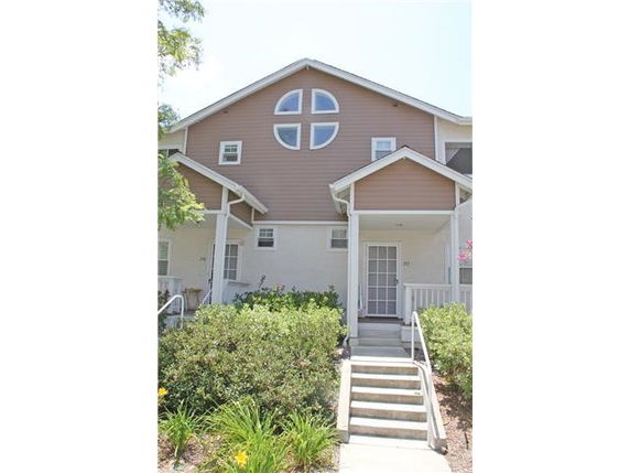 Front view of a two-story house with distinctive circular windows and a central entrance.