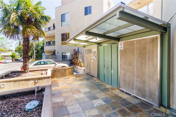 Front view of a modern multi-story building entrance with a covered walkway.