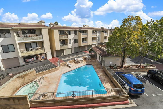 Outdoor swimming pool area adjacent to an apartment building.