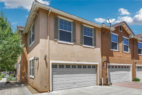Front view of a two-story townhouse with a double garage.