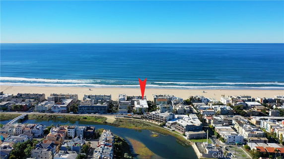 Aerial view of coastal residential area with proximity to the ocean and beach.