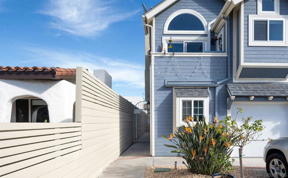 Side view of a two-story house with blue siding and white trim.