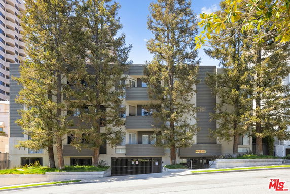 Front view of a multi-story apartment building with balconies.