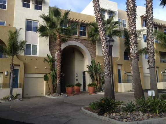 Front view of a multi-story building with entrance arch and garage.