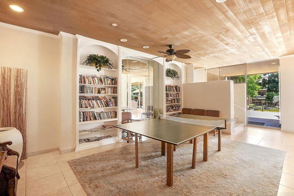 Indoor area with table tennis table, bookshelves, and seating area.