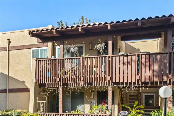 Front view of a building with a wooden balcony and decorative lights.