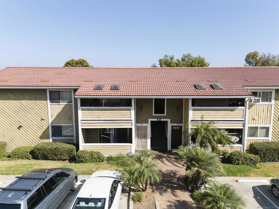 Front view of a two-story residential building with a red tile roof and balconies.