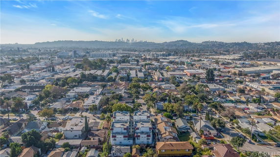 A wide-angle view of an urban area with various buildings and a distant city skyline.