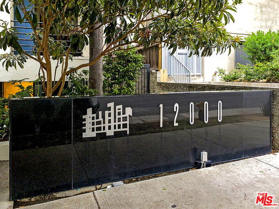 Front view of a building with a prominent black plaque displaying the number 12000.
