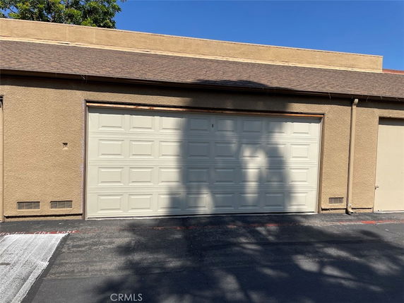 Front view of a garage with a beige double door.