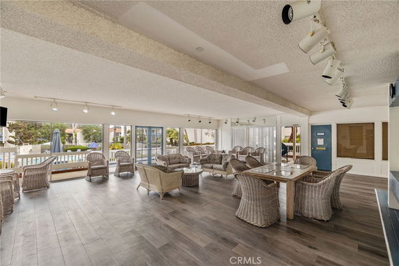 Interior view of a clubhouse with wicker furniture and large windows.
