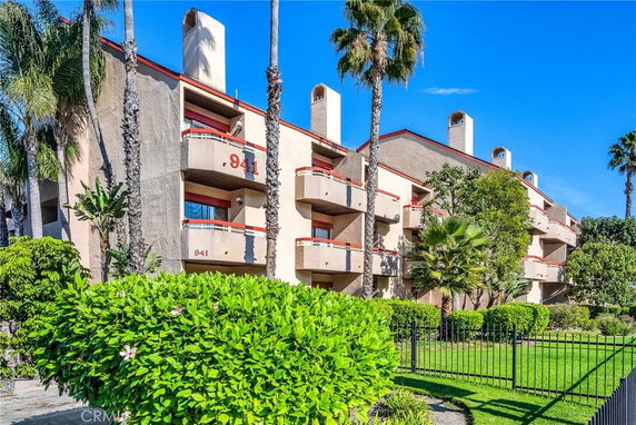 Front view of a multi-story building with balconies and chimney structures.
