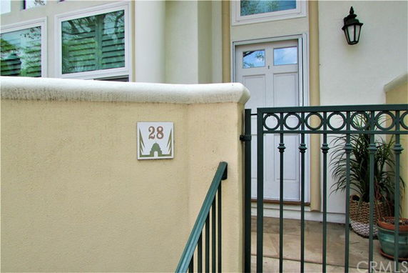 Front view of a house entrance with a gate and address number 28.