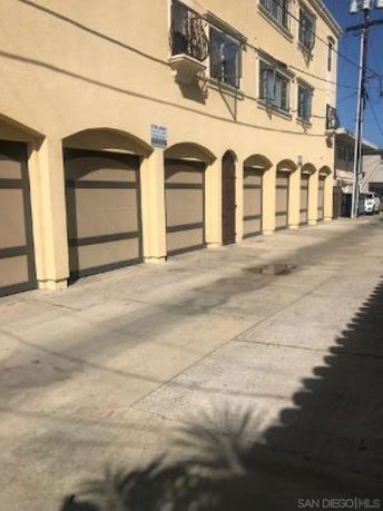 Outdoor parking area with several garage doors in a residential building.
