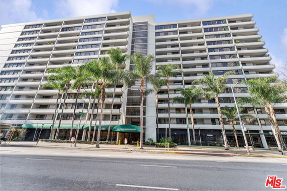 Front view of a multi-story apartment building with large balconies.